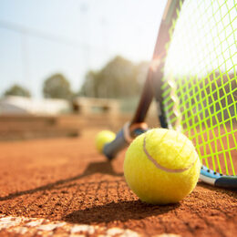 Tennisschläger und -ball auf einem Tennisplatz
