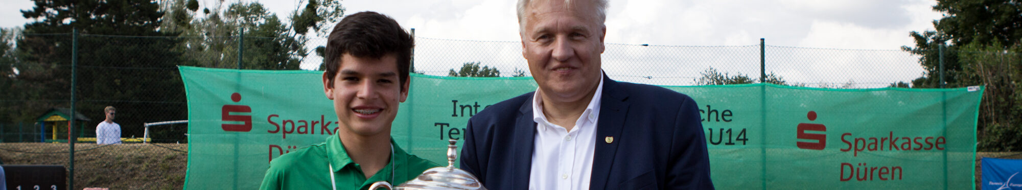 Tennisspieler Juan Carlos Prado Angelo mit Landrat Wolfgang Spelthahn auf einem Tennisplatz.