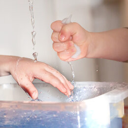Kinderhände spielen mit Wasser