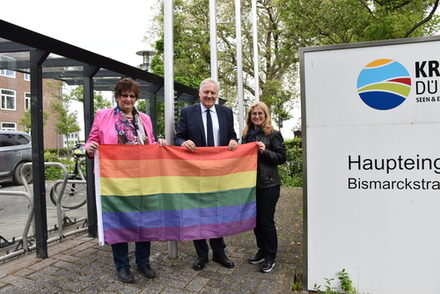 Landrat Wolfgang Spelthahn hat gemeinsam mit Gudrun Zentis, Fraktionsvorsitzende der Grünen (l.), und Andrea Kenter, Gleichstellungsbeauftragte des Kreises Düren (r.), die Regenbogenflagge gehisst, um am heutigen Internationalen Tag gegen Homo-, Bi-, Inter- und Transphobie ein klares Zeichen zu setzen.