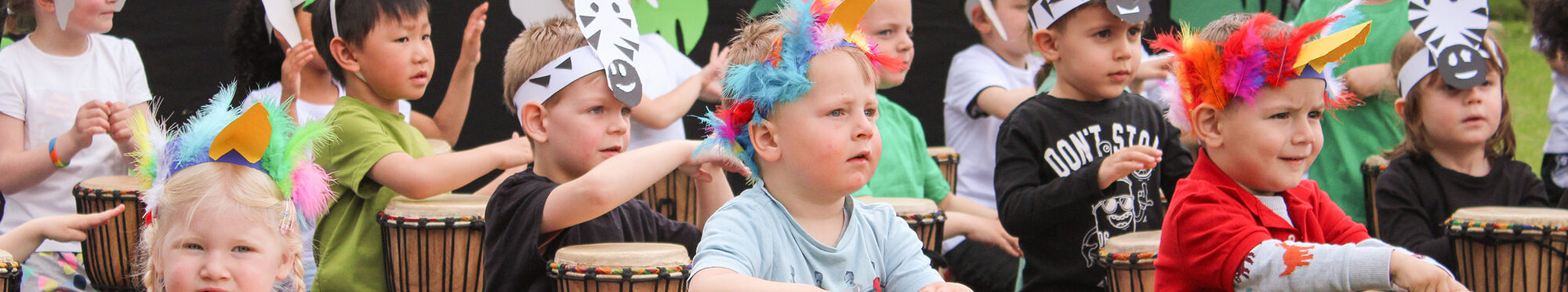 Kinder trommeln beim Jubiläums-Fest der Kita Sonnenschein in Jülich.