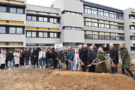 Landrat Wolfgang Spelthahn und Anwesende greifen zum Spaten, um den Baubeginn zu feiern.