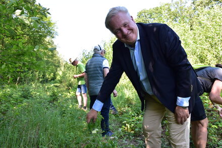 Bild zeigt Landrat Wolfgang Spelthahn neben einem der 800 Bäume im Üdinger Wald.