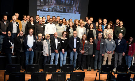 Gruppenbild der Netzwerkbeteiligten auf der Bühne