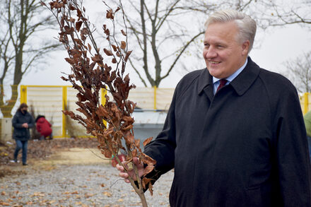 Landrat Wolfgang Spelthahn übergibt zwei Antragstellern ihre Bäume aus dem Förderprogramm.