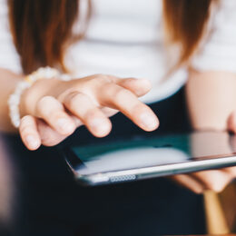 Eine Frau tippt auf ein Tablet.