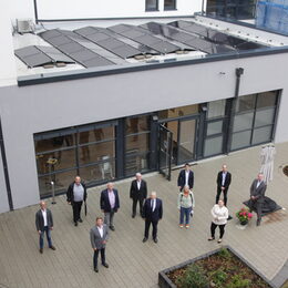 Landrat Wolfgang Spelthahn (vorne, 2. v. l.) vor der Kreishaus-Geschäftsstelle in Jülich. Auf dem Dach die große Photovoltaikanlage, die für eine umweltfreundliche Stromgewinnung sorgt.