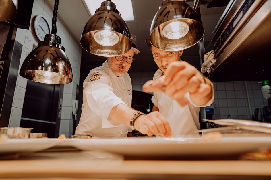 Zwei Männer, die Speisen würzen