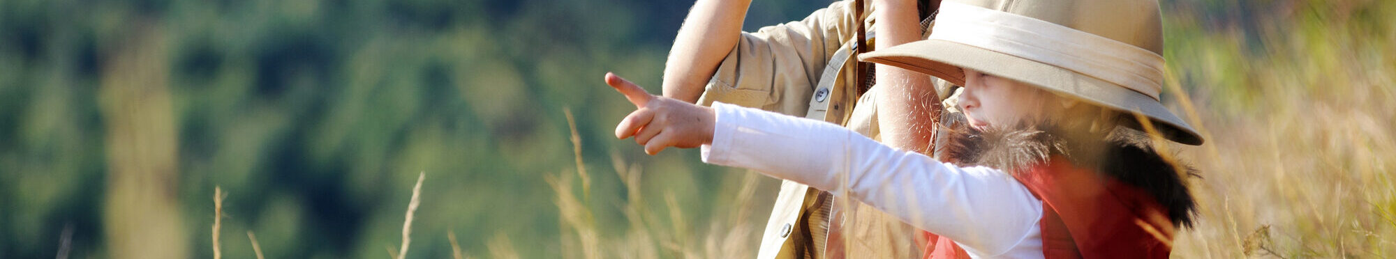 Kinder spielen draußen mit Fernsgläsern