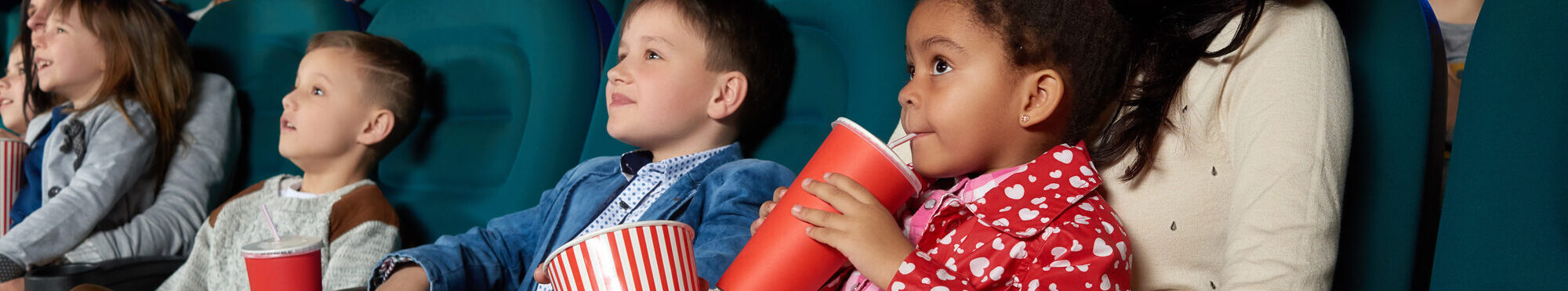 Children with parents enjoying a movie together at the cinema