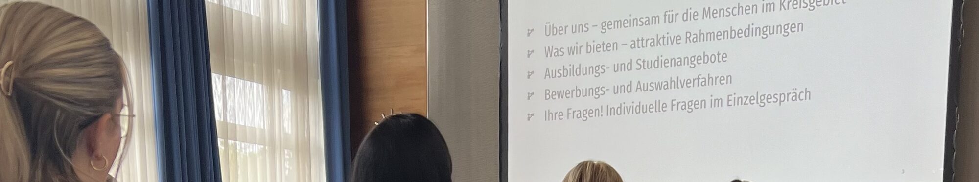 Schlüsselbänder im Vordergrund vor dem vollen Saal am Kreiskarrieretag