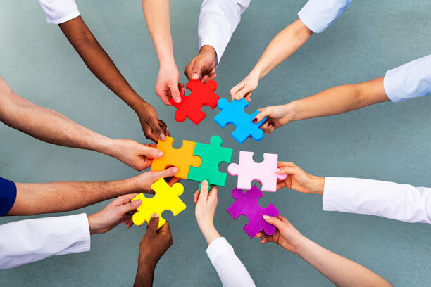 High Angle View Of Medical Team Solving Jigsaw Puzzle
