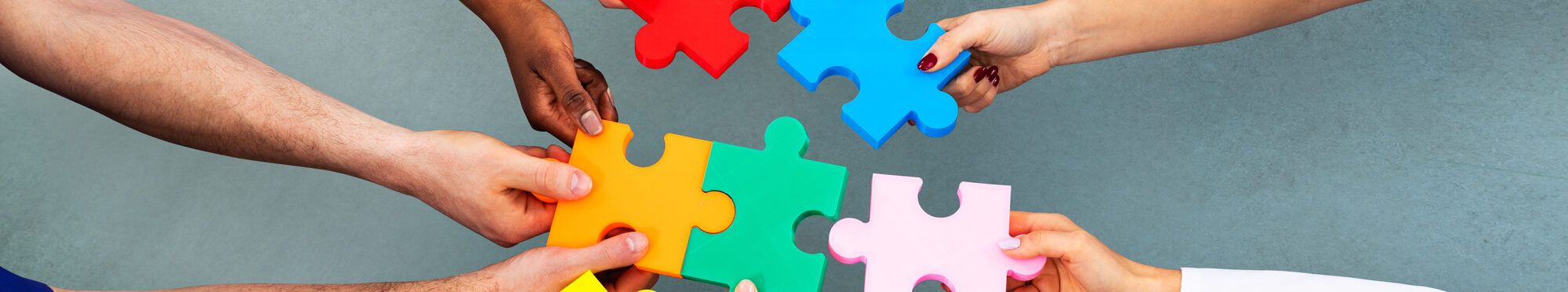 High Angle View Of Medical Team Solving Jigsaw Puzzle