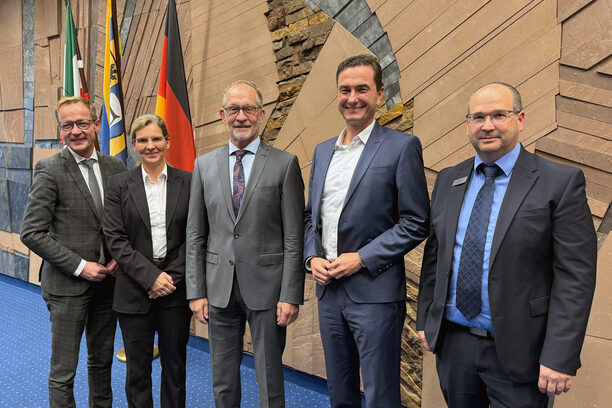 Das Bild zeigt eine Frau und vier Männer im Sitzungssaal des Kreishauses