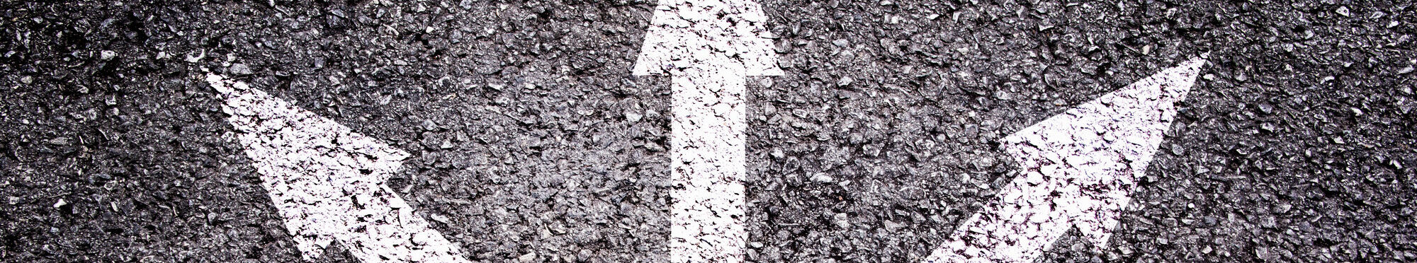 Shoes and arrows pointing in different directions on asphalt floor