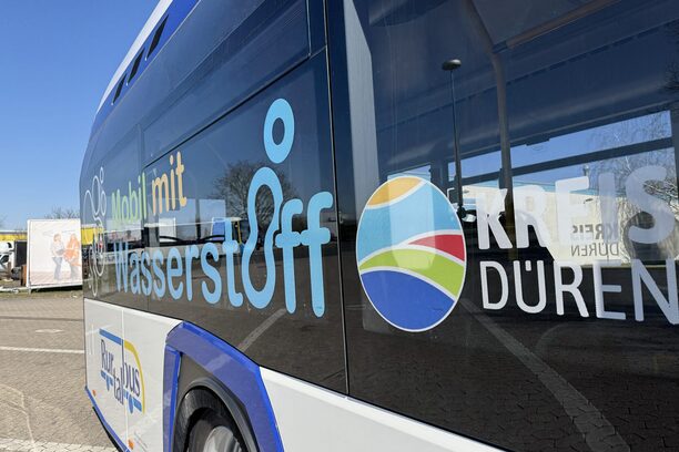 Zu sehen isst ein Wasserstoffbus von der Seite mit der Aufschrift "mobil mit Wasserstoff" und Kreis Düren