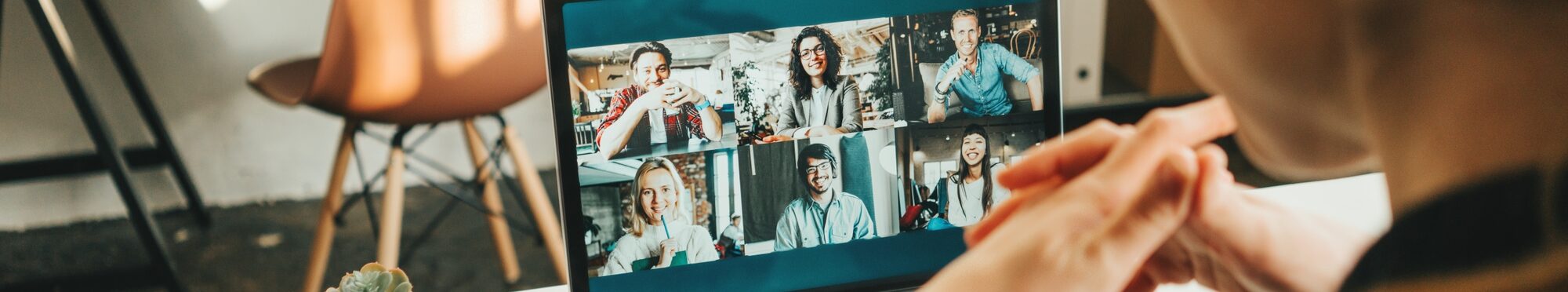 Woman has video conference with her remote team using laptop and camera