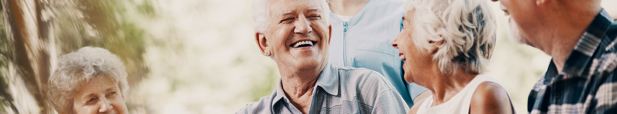 Happy elderly man with walking stick and smiling senior people relaxing in the garden