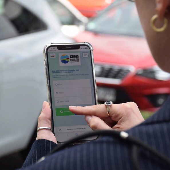 Frau am Handy auf den Seiten des Pendlerportals unterwegs